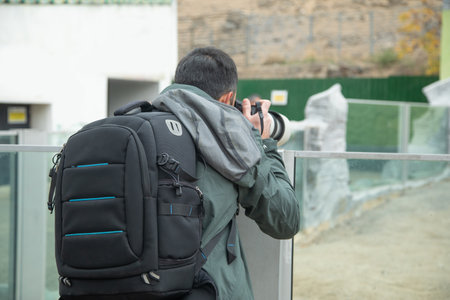 Photographer taking picture in professional camera in outdoors.