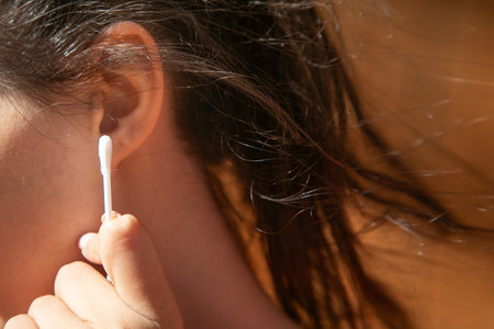 Caucasian young woman holding cotton bud.