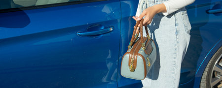Woman with handbag near the car.の写真素材