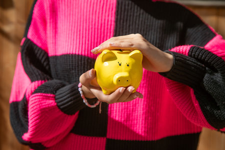 Caucasian young woman holding a piggy bank.の写真素材