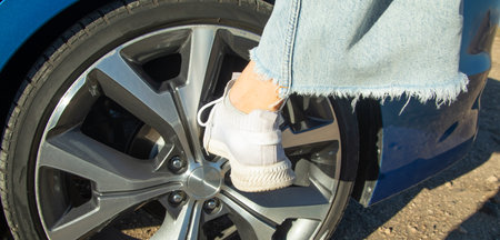 Female foot on car wheel.