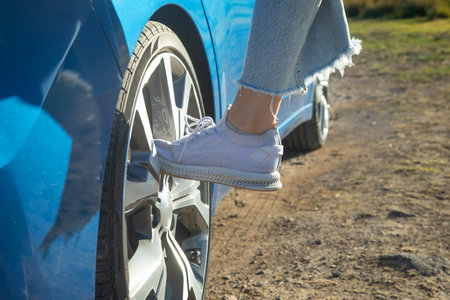 Female foot on car wheel.の写真素材