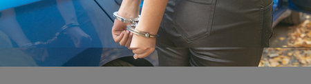 Young girl in handcuffs with a car.の写真素材