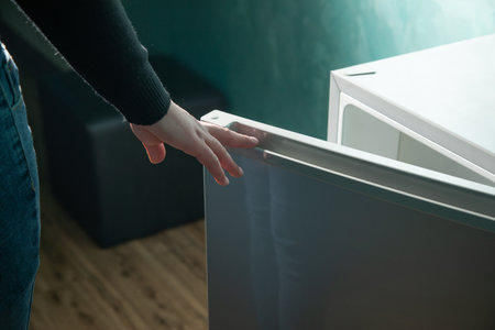 Caucasian woman opening refrigerator at home.の写真素材
