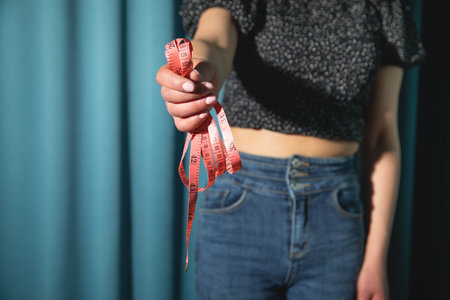 Young caucasian woman holding measuring tape.の写真素材