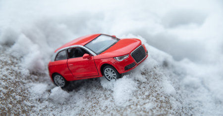 Small red toy car on snow at winter.の写真素材