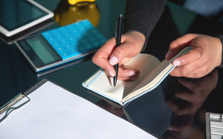 Caucasian woman writes in notepad. Business