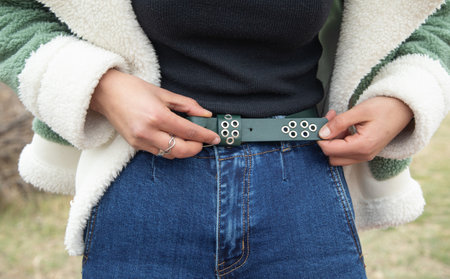 Young girl correct belt of jeans.の写真素材