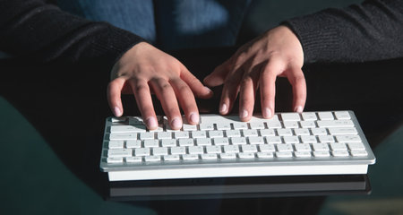 Caucasian female hands typing in computer keyboard.の写真素材