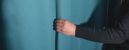 Woman correcting curtain at home.の写真素材