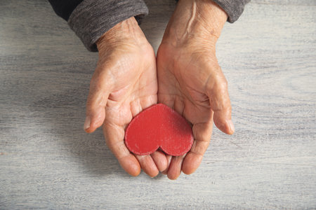 Caucasian elderly woman showing red heart.の写真素材