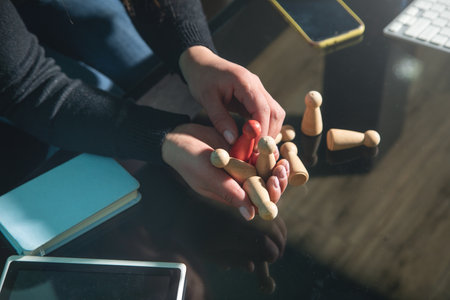 Woman showing wooden human figures. Recruitment. Leadershipの写真素材