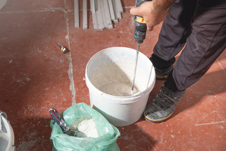 Worker mixes gypsum putty in a bucket.の写真素材
