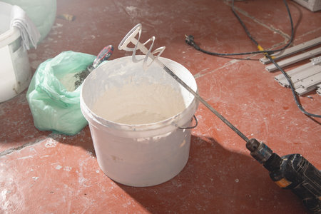 Mixing of putty. Construction mixer in a bucketの写真素材