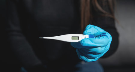 Caucasian young woman showing thermometer.の写真素材