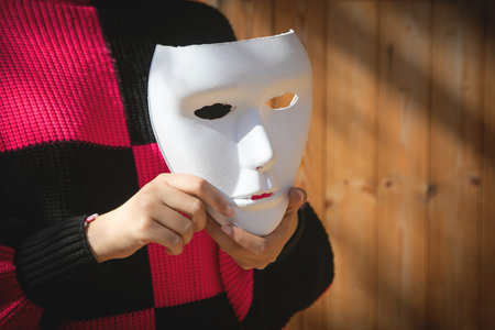 Caucasian young woman showing face mask.の写真素材
