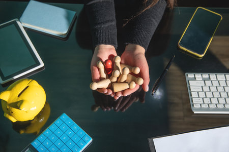 Woman showing wooden human figures. Recruitment. Leadershipの写真素材