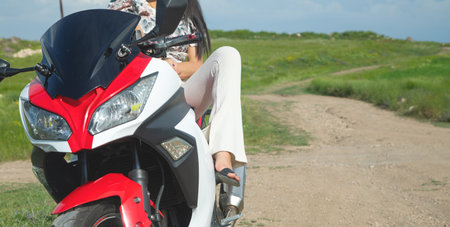 Caucasian young girl in a motorcycle at the nature.の写真素材