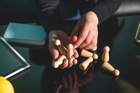 Woman showing wooden human figures. Recruitment. Leadershipの写真素材