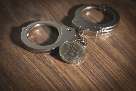 Golden bitcoins and handcuffs. Virtual currencyの写真素材