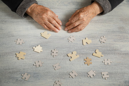 Old female hands with a jigsaw puzzle.の写真素材
