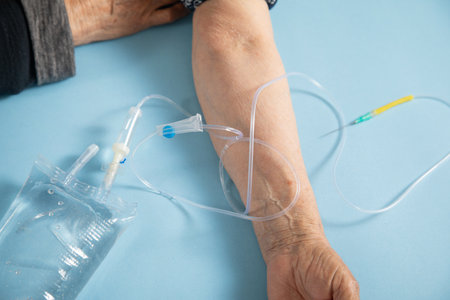 Hand of elderly patient with IV drip with infusion bag.の写真素材
