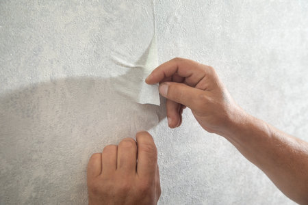Worker applying wallpaper to wall at home.の写真素材