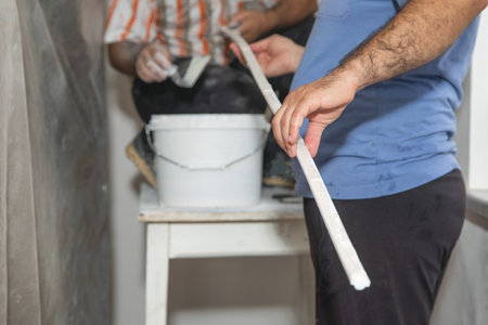Worker applying putty on material. Renovating homeの写真素材