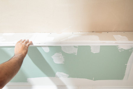 Caucasian worker renovating ceiling at home.