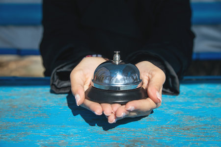 Woman ringing service bell on the table.の写真素材