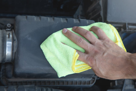 A man is wiping a car with a cloth.の写真素材