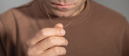 Caucasian man with a golden necklace.