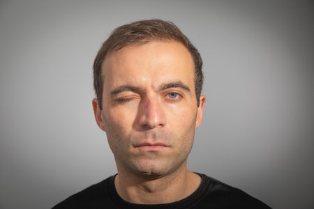 Caucasian man looking at camera and winking.の写真素材