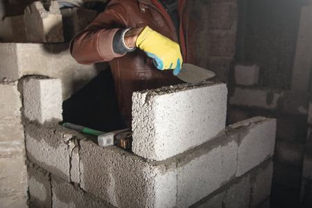 Worker builds a wall in the building site.の写真素材