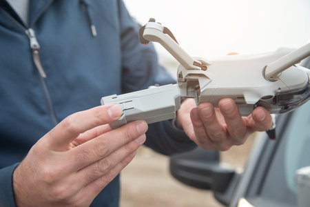 Man changing drone battery in outdoor.