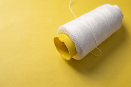 Close up of spool of white thread.