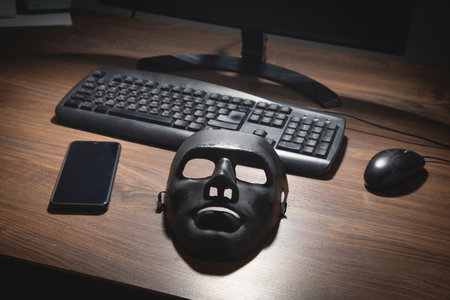 Black mask and computer on the table.の写真素材