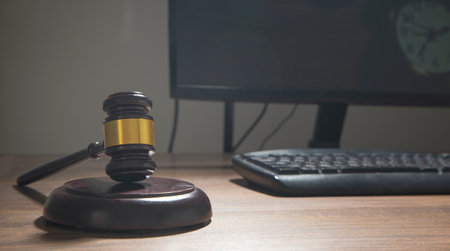 Computer with a wooden judge gavel.