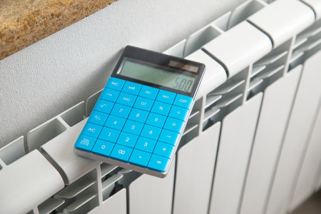 Calculator with a heating radiator at home.の写真素材