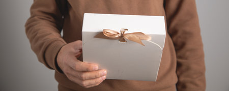 Caucasian man showing a gift box.の写真素材