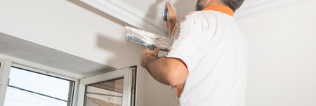 Caucasian worker renovating ceiling at home.の写真素材