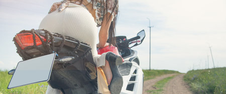 Caucasian young girl in a motorcycle at the nature.の写真素材