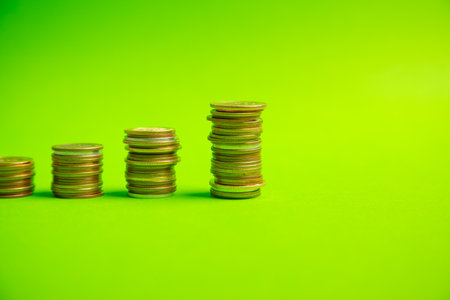 Stack of coins on the green background.の写真素材