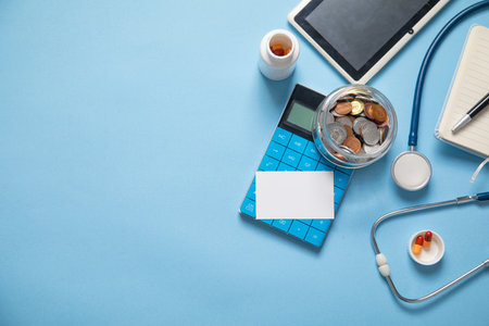Jar of coins, stethoscope, calculator, pills.の写真素材