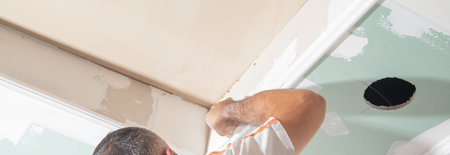 Caucasian worker renovating ceiling at home.の写真素材