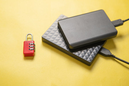 External hard disk with cable on the yellow background.の写真素材