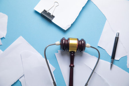 Judge gavel, stethoscope and torn documents.の写真素材