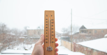 Male hand showing thermometer at winter.の写真素材