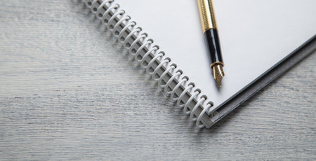 Notepad, pen, with a different business objects on the table.