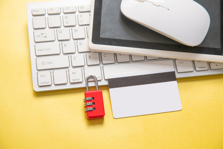 Padlock, credit card, computer keyboard on the yellow background.の写真素材